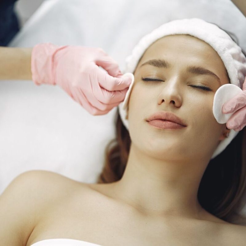 Woman enjoying a soothing facial treatment in a serene spa setting, promoting relaxation and beauty.